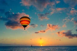 Hot air balloon over the sea at sunset