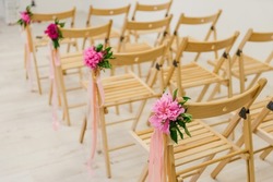 peonies floristry for the wedding ceremony wooden chairs white walls parquet bright room pink ribbons