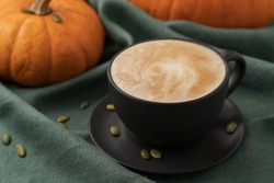 Pumpkin spicy latte in black cup on linne cloth, shallow focus