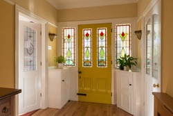 Front door and hallway of a house in England with stained glass window in the door.
