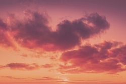 Сloudy sky at sunset.  Sky texture, abstract nature background in trendy Calming Coral color