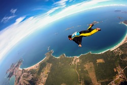 Skydive wing suit flying over Brazilian beach, adventure freedom concept