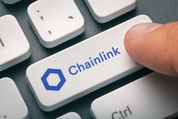Cryptocurrency trading concept: Male hand pressing computer key with Chainlink | Link logo. Cryptocurrency mining, trading, market concept.