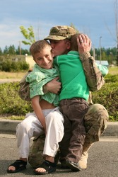 A soldier saying goodbye to his kids before deployment