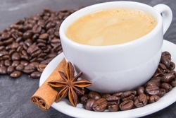 Coffee in white cup and roasted fragrant coffee beans with star of anise and cinnamon stick