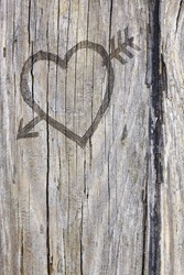 Love heart and arrow graffiti carved into old wood