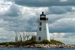Sun breaks through storm clouds at old tower of Black Rock Harbor lighthouse, also known as Fayerweather Island light, in Bridgeport, Connecticut.