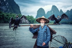 Cormorant Fisherman in Traditional showing of his birds on Li River near Xingping, Guangxi province, China.