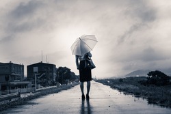 Woman are holding an umbrella, dark image