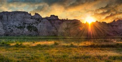 Badlands Prairie Sunrise - sun rises over ridges and grasslands of the Badlands in South Dakota