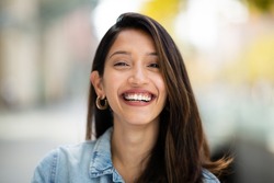 Close up front portrait beautiful woman laughing outdoors 