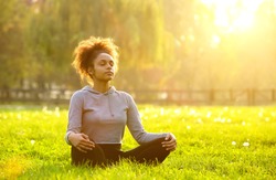 Young african american woman meditating in nature 