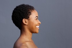 Side portrait of beautiful smiling black female model against gray background
