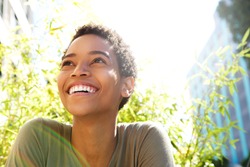 Close up portrait of beautiful young black woman smiling outdoors