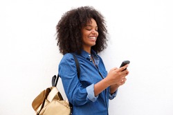 Portrait of smiling black woman with smart phone and backpack