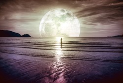 Super moon. Colorful sky with bright full moon over seascape and silhouette of woman standing in the sea . Serenity nature background, outdoor at gloaming. The moon taken with my own camera.