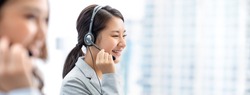Smiling beautiful Asian woman working in call center office as a telemarketer