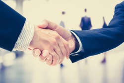Handshake of businessmen on blur businesspeople background, vintage tone - greeting, dealing, merger and a acquisition concepts