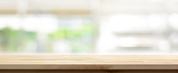Wood table top on blur kitchen window background, panoramic banner - can be used for display or montage your products (or foods)