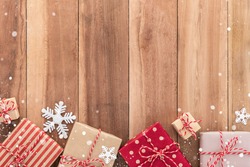 Gift boxes and Christmas ornaments on wood background, border design, top view