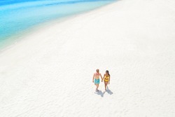 Couple walking on white sand beach in summer, bird eye view - tourist and vocation concepts