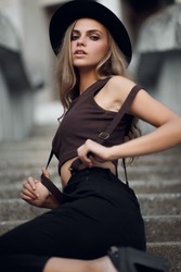 Closeup fashion woman portrait of young pretty trendy girl posing in city