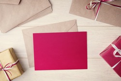 Blank red card mock up among envelopes and gift boxes