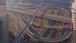 Aerial view of empty highway interchange in Dubai downtown after epidemic lockdown. Cityscapes with disappearing traffic on a bridge and streets. Roads and lanes crossroads without cars, Dubai, United