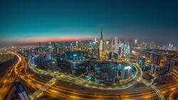 Panoramic skyline of Dubai with business bay and downtown district day to night timelapse. Aerial wide angle view of many modern skyscrapers with traffic on al khail road after sunset.