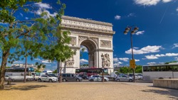 The Arc de Triomphe (Triumphal Arch of the Star) is one of the most famous monuments in Paris, standing at the western end of the Champs-Elyseees. Traffic on circle road. Blue
