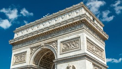 Top of the Arc de Triomphe (Triumphal Arch of the Star) timelapse is one of the most famous monuments in Paris, standing at the western end of the Champs-Elyseees. Blue cloudy sky at summer day