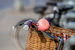 close up of bicycle handlebars with bell on a blurred street background