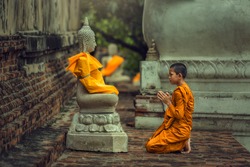Novices monk vipassana meditation at front of Buddha statue
