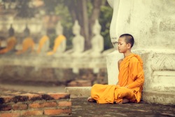Novices monk vipassana meditation at Ayutthaya Historical Park in Thailand