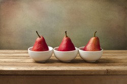 Fine art still life with red pears on wooden table