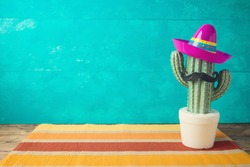 Cinco de Mayo holiday background with Mexican cactus and  party sombrero hat on wooden table 