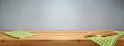 Empty wooden table with tablecloth and cutting board over gray wall background. Spring and easter mock up for design