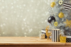 Christmas background with Christmas tree on wooden table. Black, golden and silver ornaments
