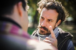Close-up finger pointing of two very angry, nervous and upset men in an aggressive and fierce quarrel conflict on the verge of a physical confrontation and a fight. Concept of male conflict