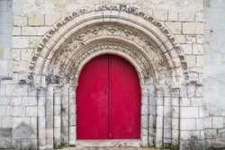 Very old red church door in Loire region, France