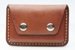 Closed brown leather cardholder front view isolated on studio background