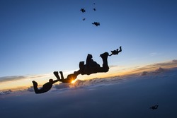 Skydiving formation at sunset