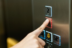 People pressing the button in the lift and select the first floor by using the forefinger. Elevator control panel in small building close up. Bell alphabet on the button in the passenger lift.