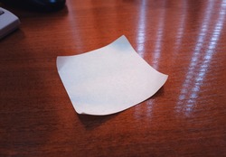 Blank office sticky note on wooden table bokeh background