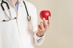 Image of male doctor holding apple.