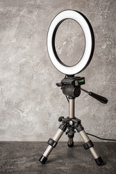 Modern circular neon led lamp for make-up artist or photographers on gray concrete background