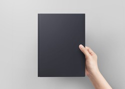 Hand women holding black book cover blank top view.  Blank book cover.