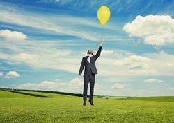 laughing man flying with yellow balloon 
