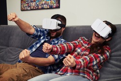 A young man and woman in casual clothes playing racing game using virtual reality headset