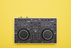 Flat lay of mixing console against yellow background. Electronic device, used for recording sound